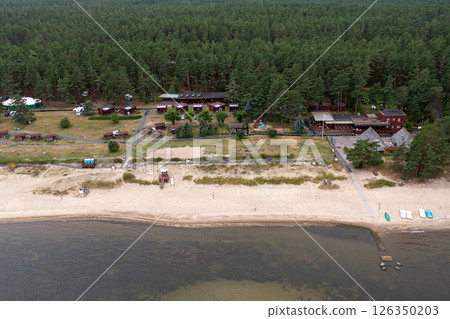 Aerial view of a tranquil seaside resort amid lush forest during summer season Aerial view of a tranquil seaside resort amid lush forest during summer season 126350203