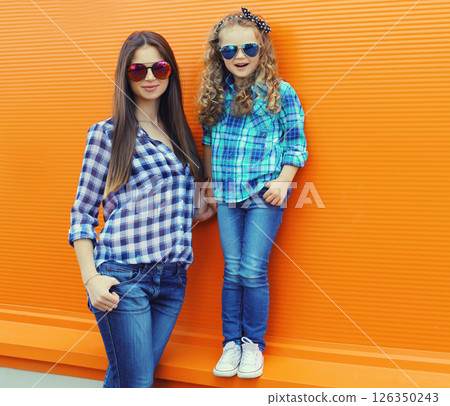 Stylish mother and child daughter together, happy mom with kid girl in casual clothing in the city Stylish mother and child daughter together, happy mom with kid girl in casual clothing in the city 126350243