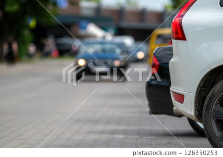 White car parked on city street. Shallow depth of feld White car parked on city street. Shallow depth of feld 126350253