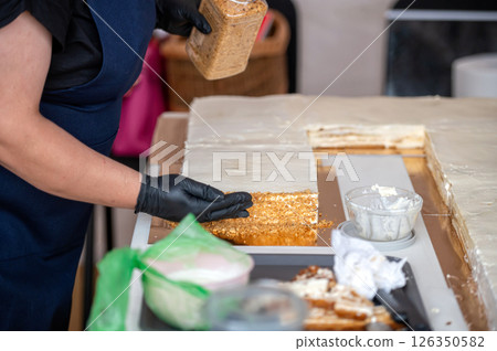 Baker assembling cake layers. Shallow depth of feld 126350582