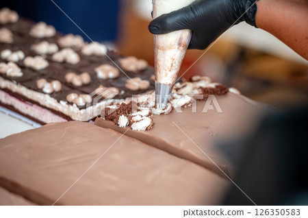 Baker decorating chocolate cake. Background with selective focus and copy space. 126350583