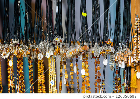 Colorful handmade necklaces displayed at a local market in the afternoon sun 126350692