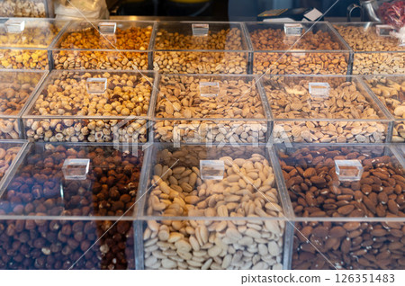Assorted nuts displayed in clear containers at a market stall in the late afternoon Assorted nuts displayed in clear containers at a market stall in the late afternoon 126351483