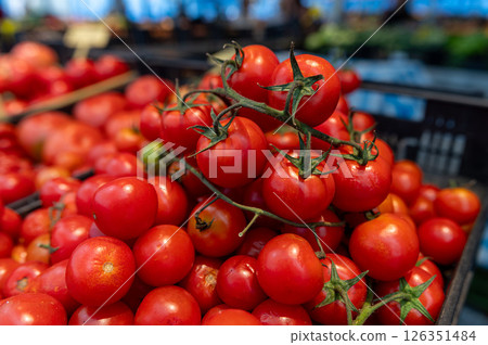 Fresh tomatoes stacked in a vibrant market with natural lighting during the day Fresh tomatoes stacked in a vibrant market with natural lighting during the day 126351484