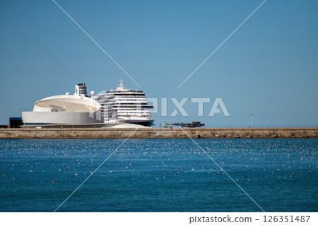 Cruise ship docked at a modern terminal on a clear day near the coast Cruise ship docked at a modern terminal on a clear day near the coast 126351487