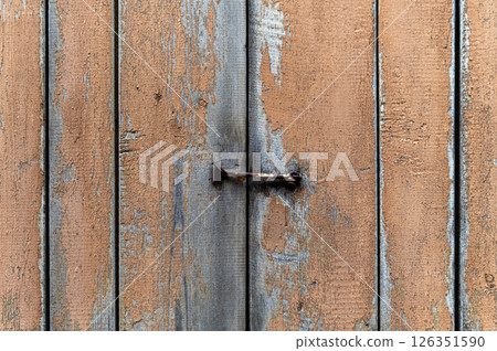 Detailed close-up of weathered wooden fence with rusty nail in an outdoor setting 126351590