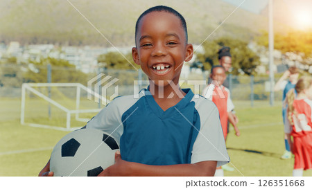 Child, portrait and training with smile, soccer and ball with pride, learning or outdoor for development. Boy, excited and football team with goals, exercise and happy with fitness on grass field 126351668