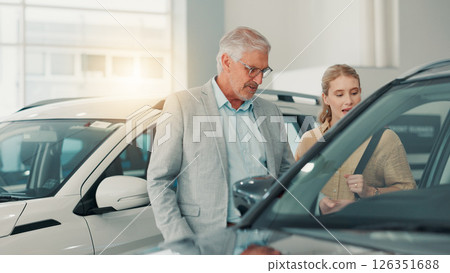 People, customer and salesman with discussion in car dealership, transport model and rental service. Motor showroom, woman and mature seller with pitch for vehicle features, assistance and talking 126351688