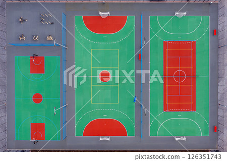 Aerial view of vibrant multi-sport courts in urban area with basketball and tennis sections 126351743