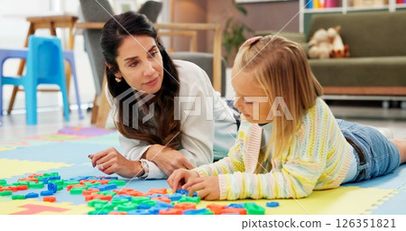 Therapist, child and letters toys in office for mental health, examination or progress. Psychologist woman, pediatrics and girl for wellness, clinic or consultation for patient support or development 126351821