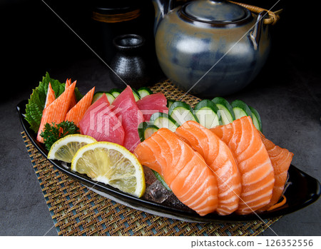 Assorted sashimi platter with salmon, tuna, kani, cucumber, and lemon 126352556