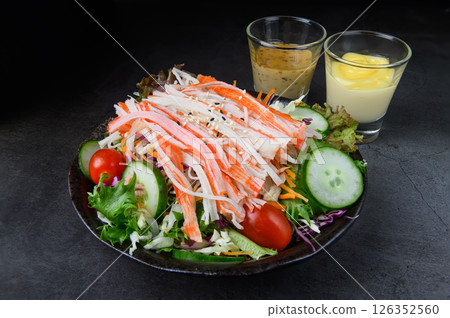 Imitation crab stick salad with fresh vegetables and dipping sauces 126352560