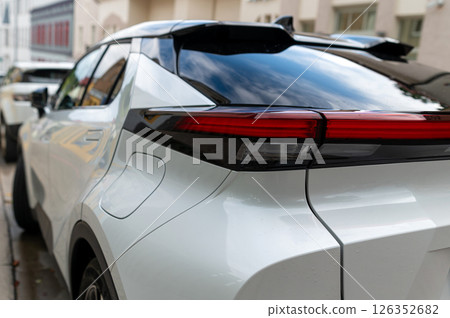 Modern electric vehicle parked along a cobblestone street in a town on a sunny day 126352682
