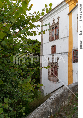 Historic building with ornate architecture surrounded by lush greenery in a quiet setting 126352686