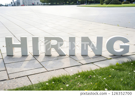 HIRING letters displayed on outdoor plaza tiles, employment opportunity and recruitment campaign 126352700