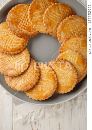 Sable Breton is a classic French butter cookie traditionally made with a shortbread type of dough and salted butter closeup on the plate on the table. Vertical top view 126352991