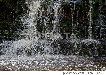 Closeup of falling and splashing streams of water, Ivande waterfall, Latvia Closeup of falling and splashing streams of water, Ivande waterfall, Latvia 126354230