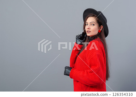 young teenage female with elegant black hat and gloves, dressed in a red sweater, isolated on gray young teenage female with elegant black hat and gloves, dressed in a red sweater, isolated on gray 126354310