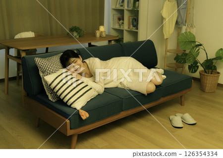 晚上躺在沙發上的年輕女子 晚上躺在沙發上的年輕女子 126354334