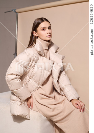 beautiful fashion female model in beige down jacket and long wool turtleneck dress in studio. Autumn winter total fashion beige look 126354639