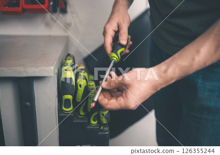 Man Choosing A Screwdriver In Screwdriver Set Man Choosing A Screwdriver In Screwdriver Set 126355244