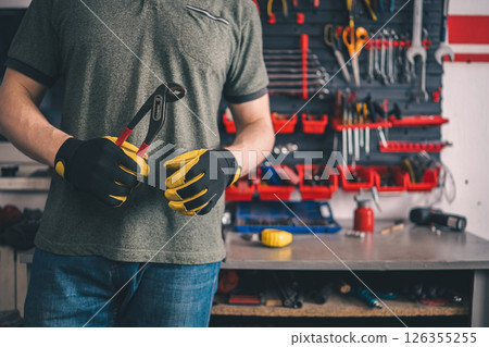 Worker Holding Pliers At Workbench 126355255