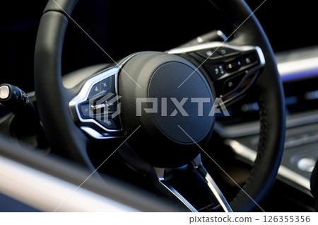 A close-up of a modern car's steering wheel with control buttons A close-up of a modern car's steering wheel with control buttons 126355356