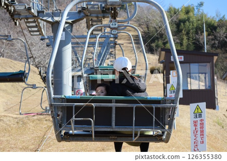 Parent and child riding a lift Parent and child riding a lift 126355380