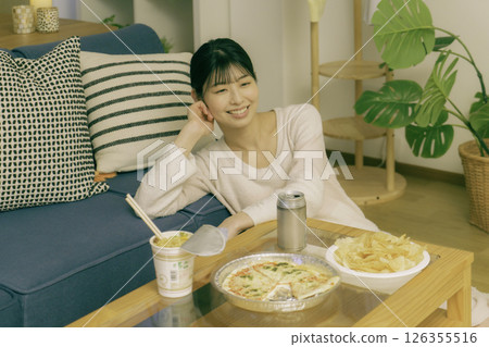 Young woman drinking alcohol in the living room at night 126355516