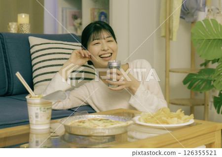 年輕女子晚上在客廳喝酒 126355521