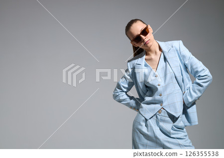 High fashion portrait of young confident female model in blue three-piece suit. Monochrome blue outfit 126355538