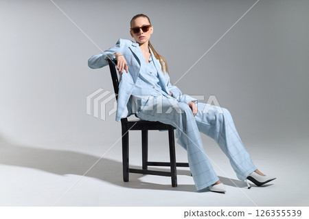 High fashion portrait of young confident female model in blue three-piece suit. Monochrome blue outfit 126355539