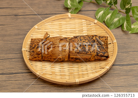 Stock photo of Kagoshima Prefecture's local confectionery, ash-maki, a whole piece wrapped in bamboo skin Stock photo of Kagoshima Prefecture's local confectionery, ash-maki, a whole piece wrapped in bamboo skin 126355713