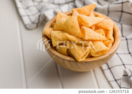 Salted snack chips in bowl on white table. 126355718