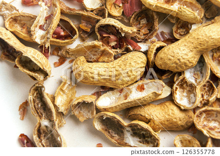 Scattered peanut leftovers. Nut shells on a dinner plate. Macro. Scattered peanut leftovers. Nut shells on a dinner plate. Macro. 126355778