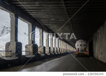 Trucks drive through mountain passes on the Georgian Military Road, major route through the Caucasus from Georgia to Russia 126356143