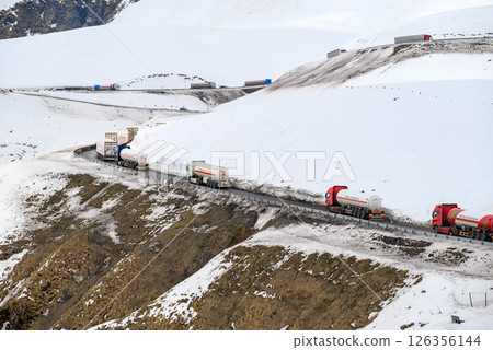 Trucks drive through mountain passes on the Georgian Military Road, major route through the Caucasus from Georgia to Russia 126356144