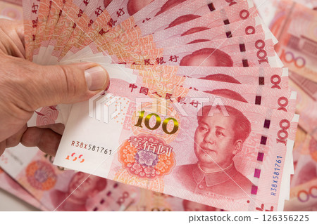 Big pile of different Chinese yuan banknotes 100 in hand. Chinese paper currency Yuan renminbi banknotes and coins. Copy space. Close up. Big pile of different Chinese yuan banknotes 100 in hand. Chinese paper currency Yuan renminbi banknotes and coins. Copy space. Close up. 126356225