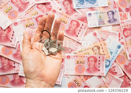 Keys from new house in hand on background of Chinese currency. Close up. 126356229