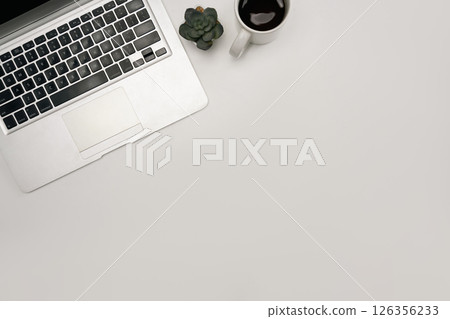 Overhead image of a tidy desk with laptop, a cup of coffee, and plant Overhead image of a tidy desk with laptop, a cup of coffee, and plant 126356233