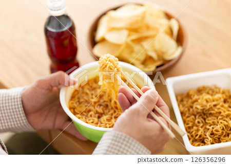 Middle-aged man binge eating junk food 126356296