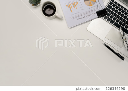 Top view of modern office desk with financial report, laptop, coffee cup, and glasses 126356298