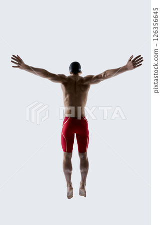 Rear view photo of professional swimmer stretches body showing perfect muscle symmetry against white studio background. Dynamic photo. 126356645