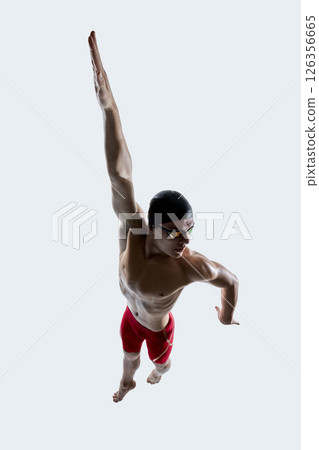 Male swimmer mid turn lifts one arm upward and curls other arm backward with body twist during motion sequence against white background. 126356665
