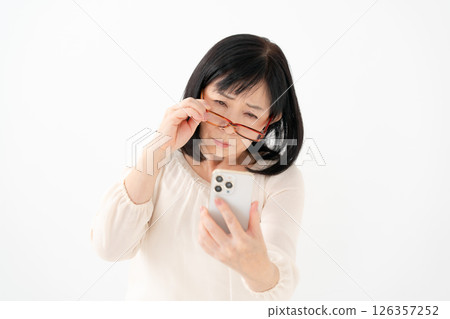 Female senior smartphone presbyopia Female senior smartphone presbyopia 126357252