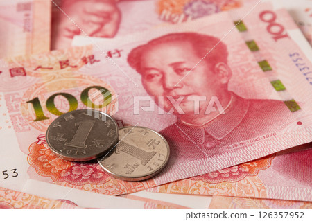Chinese coins lying on 100 banknotes. Chinese paper currency Yuan renminbi banknotes. Cash. Close up. 126357952