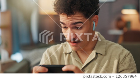 Man, smartphone and shock with earphones for gaming in home, streaming and happy surprise with esport. Gamer, wow and person in house with mobile app for videogame, wireless audio tech and tournament 126357964