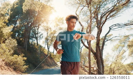 Fitness, running and watch with man outdoor on road in forest for cardio, challenge or performance. Exercise, time and tracking with athlete or runner in nature for sports, training or workout 126358011