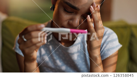 Hands, pregnancy test and stress with woman on sofa in living room of home waiting for fertility results. Anxiety, IVF and kit with person closeup in apartment for crisis, disaster or mistake 126358045