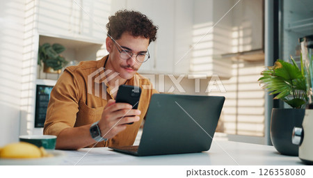 Home, cellphone and man in kitchen, laptop and online reading with creativity, project research and review. Social media, freelancer or person with pc, smartphone or feedback for proposal or chatting Home, cellphone and man in kitchen, laptop and online reading with creativity, project research and review. Social media, freelancer or person with pc, smartphone or feedback for proposal or chatting 126358080